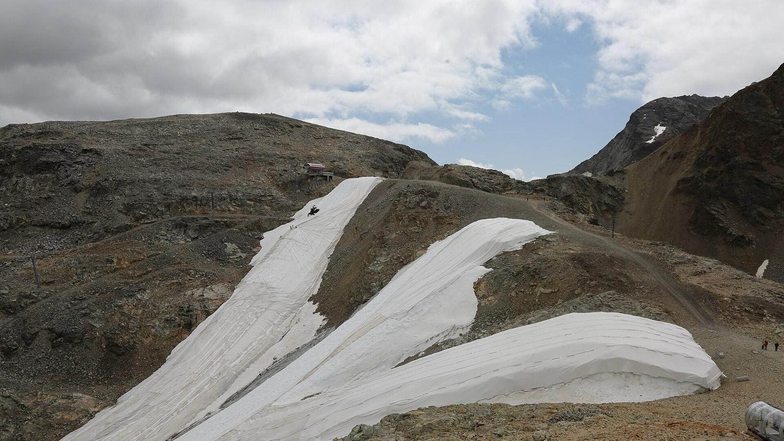 Bâches blanches déroulées sur la neige à la Diavolezza, dans les Alpes suisses, en juillet 2023