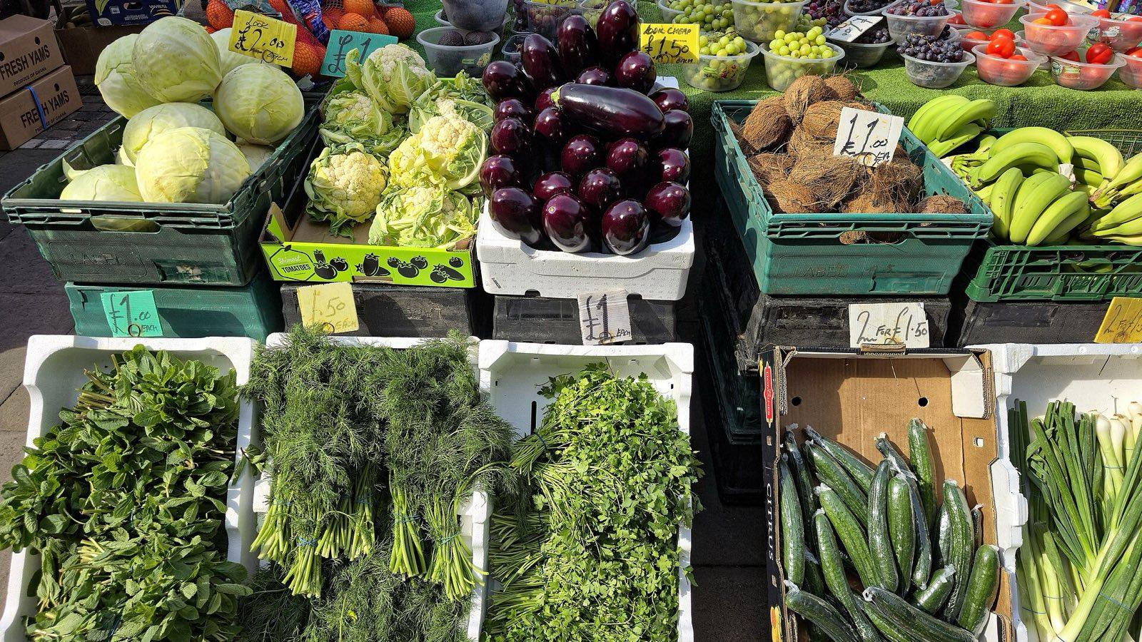 Étal de fruits et légumes en plein air, cagettes de pommes, de légumes et de salades avec leurs prix