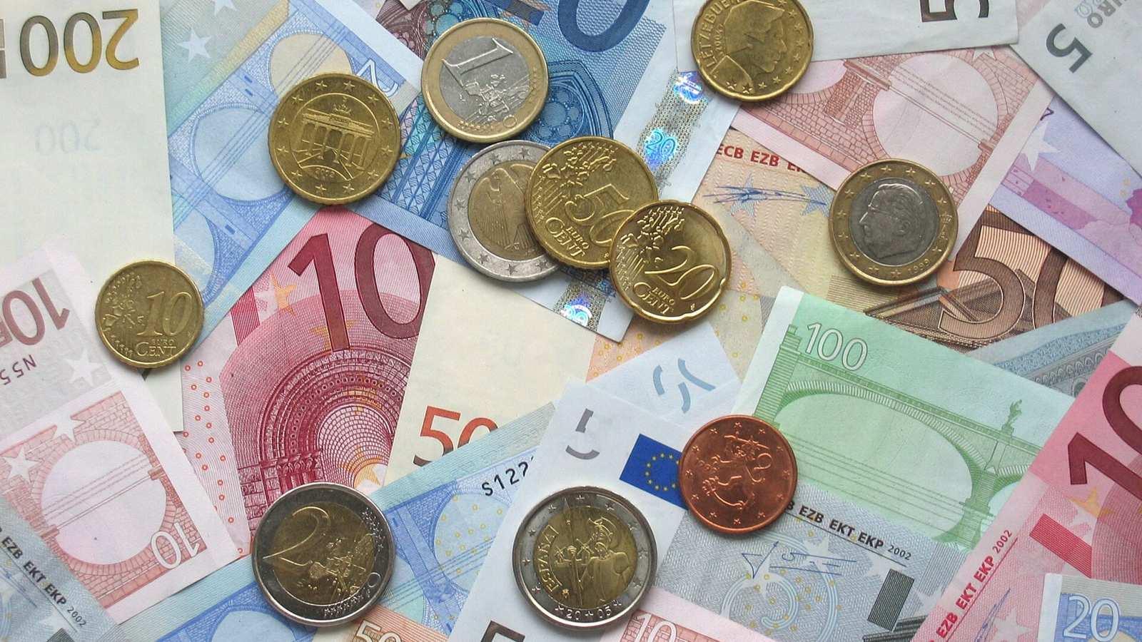 Billets et pièces en euros de différentes valeurs posés à plat