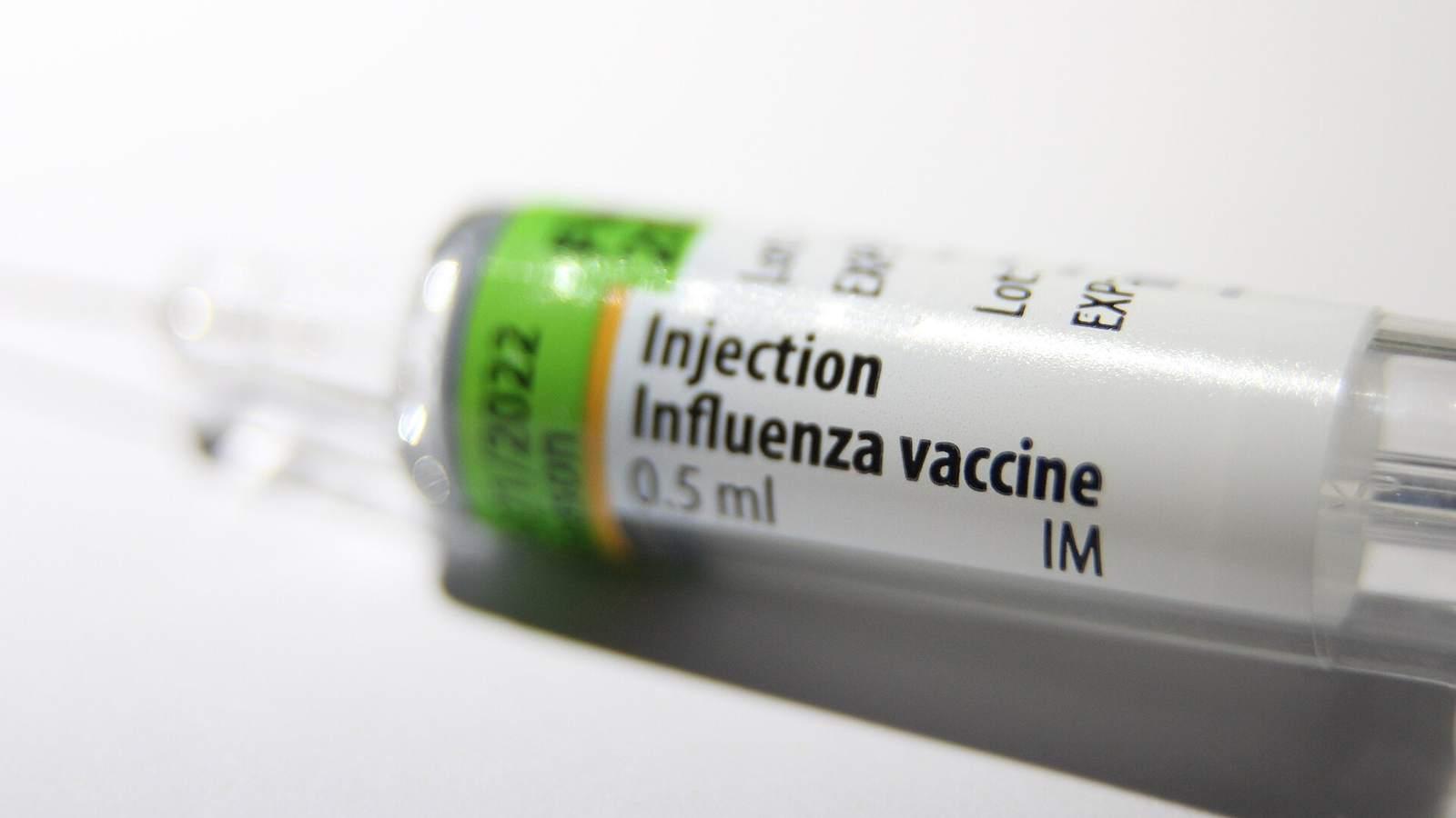 Seringue préremplie de vaccin contre la grippe, étiquetée « Influenza vaccine 0.5 ml », posée sur un fond blanc