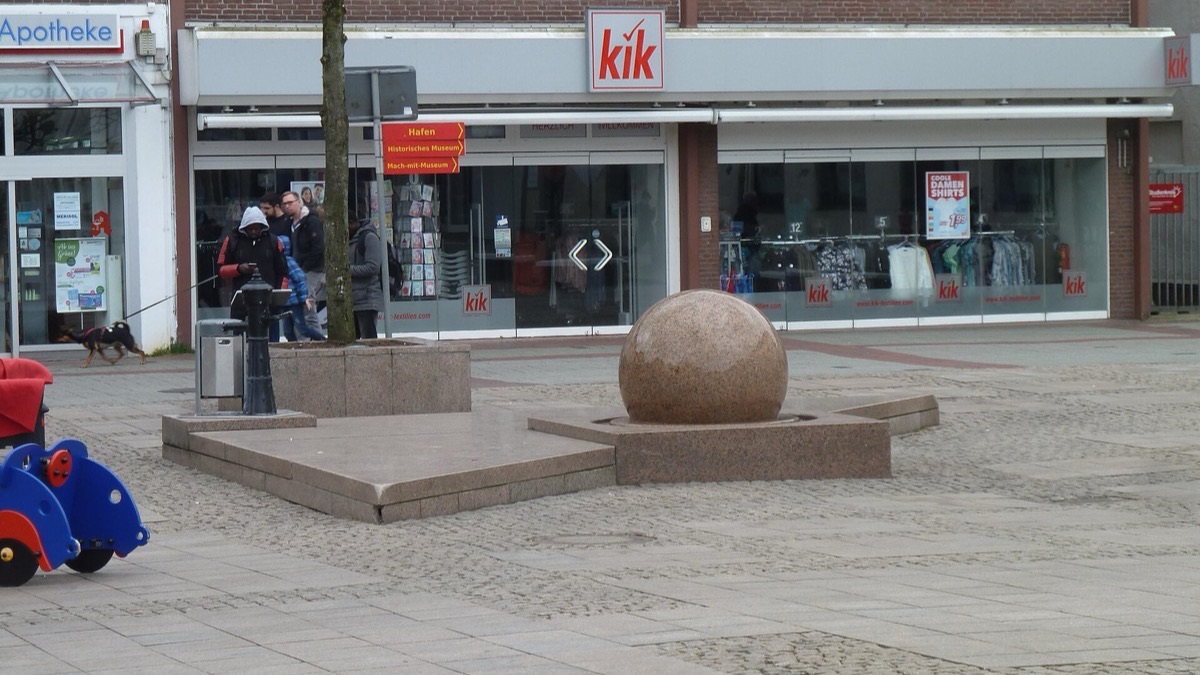 Grosses boules de ciment alignées au bord d'un trottoir en ville pour empêcher le stationnement des voitures